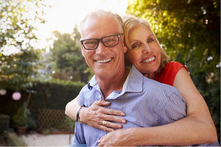 senior couple hugging and smiling after learning about CEREC crowns