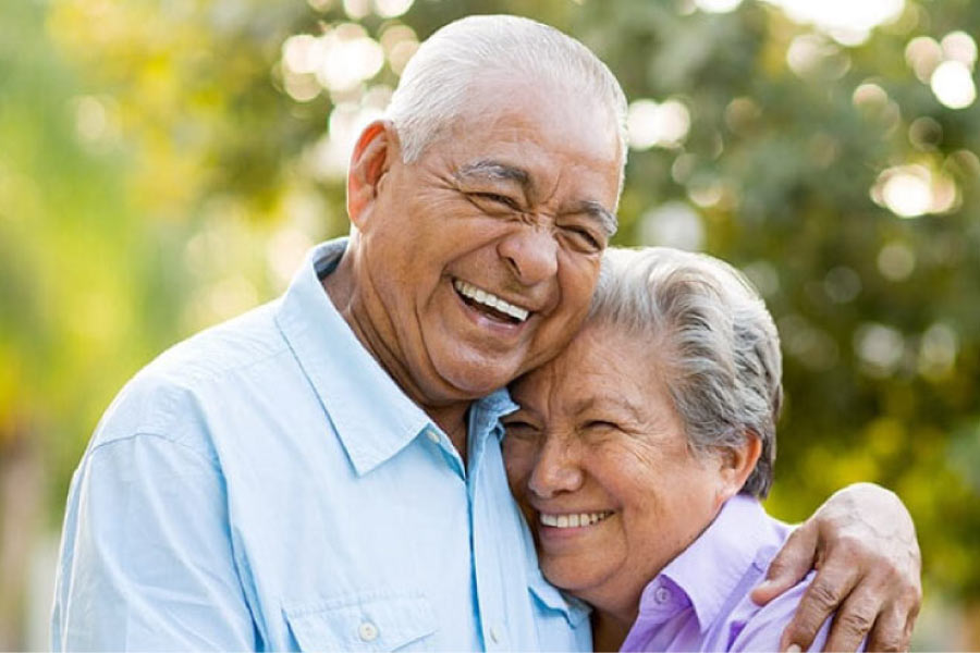 senior couple hug and smile after learning about diabetes and oral health