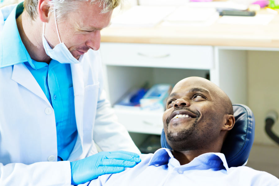 man sits in the dental chair discussing gum health with the dentist